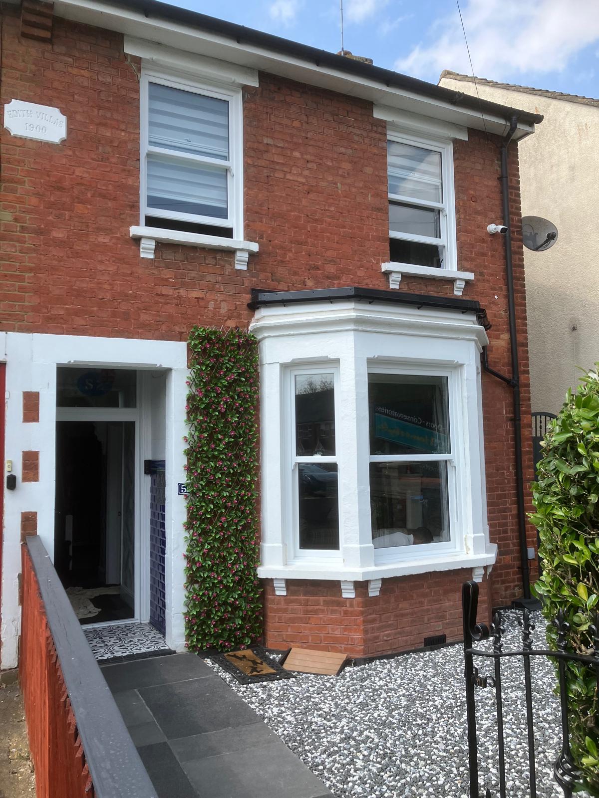 White uPVC bay window viewed from inside with planting outside