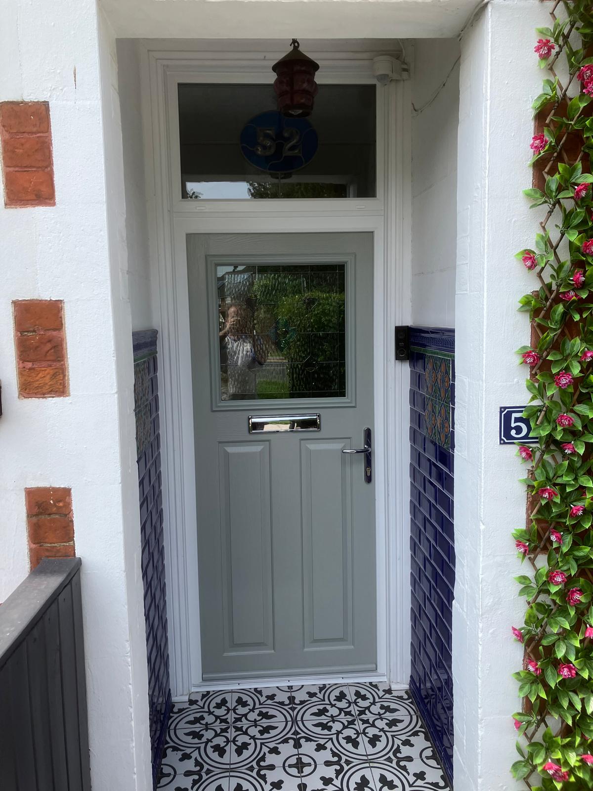 Sage green composite front door with house number 5 and climbing rose