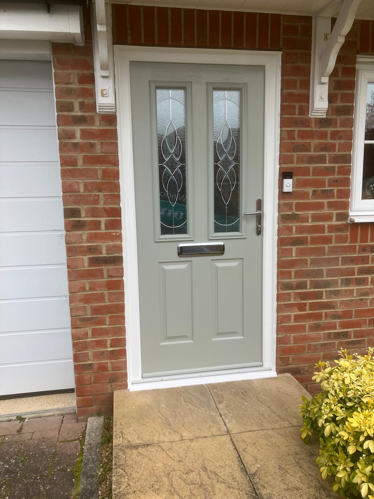 Sage grey composite front door fitted in a brick surround