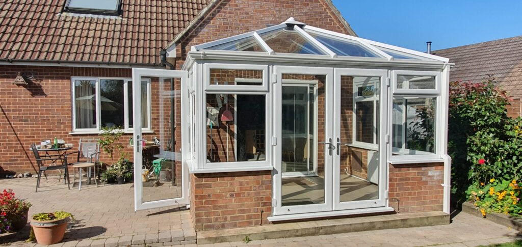 White uPVC conservatory with windows on a brick house