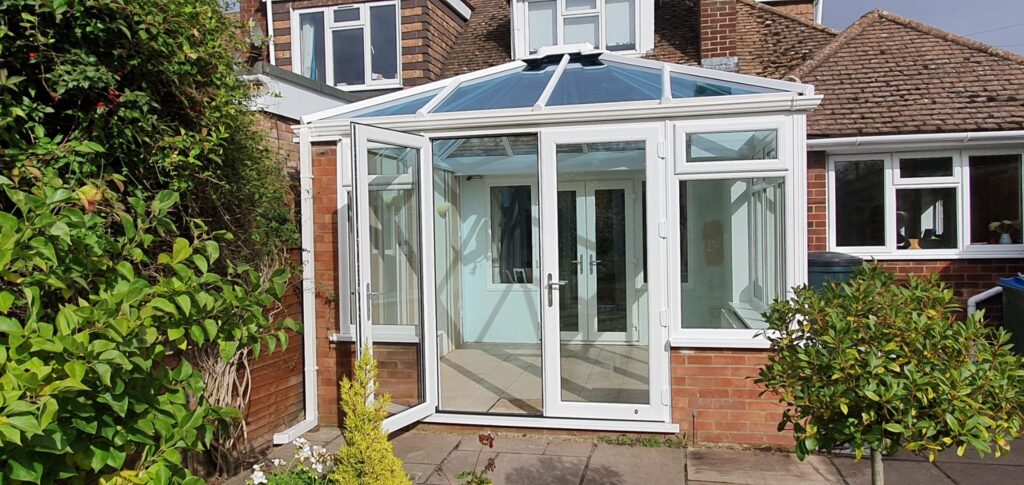 White uPVC conservatory with French doors on a brick house