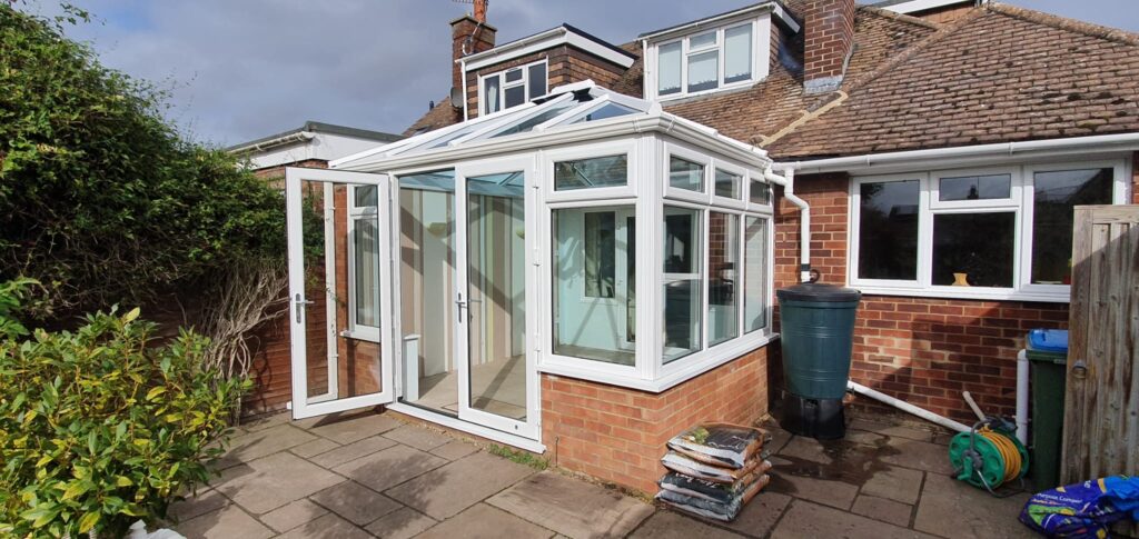 White uPVC conservatory with glazed windows on a brick house