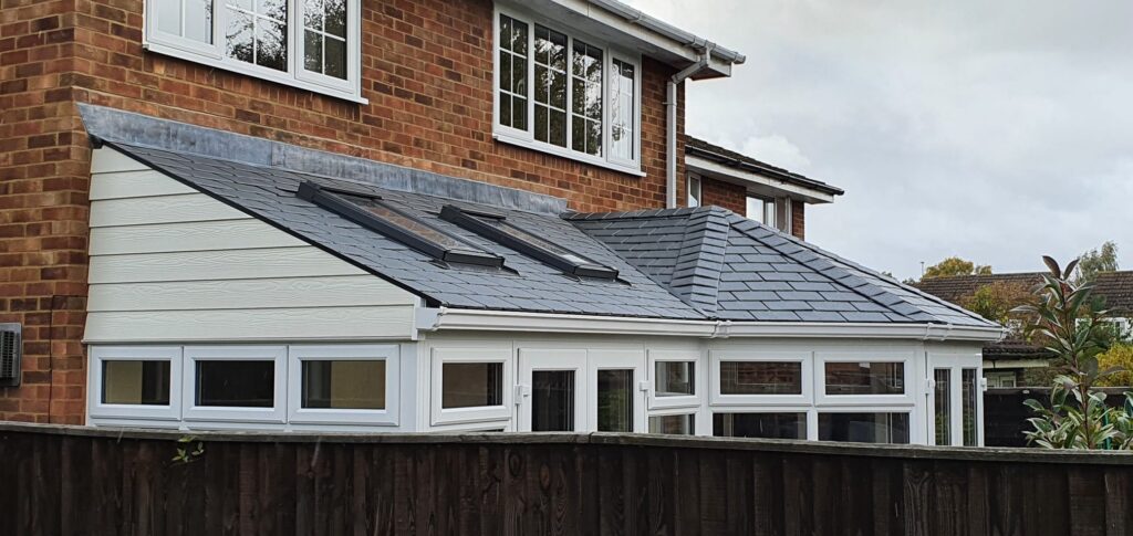 Grey tiled warm-roof conservatory with rooflights on a brick house